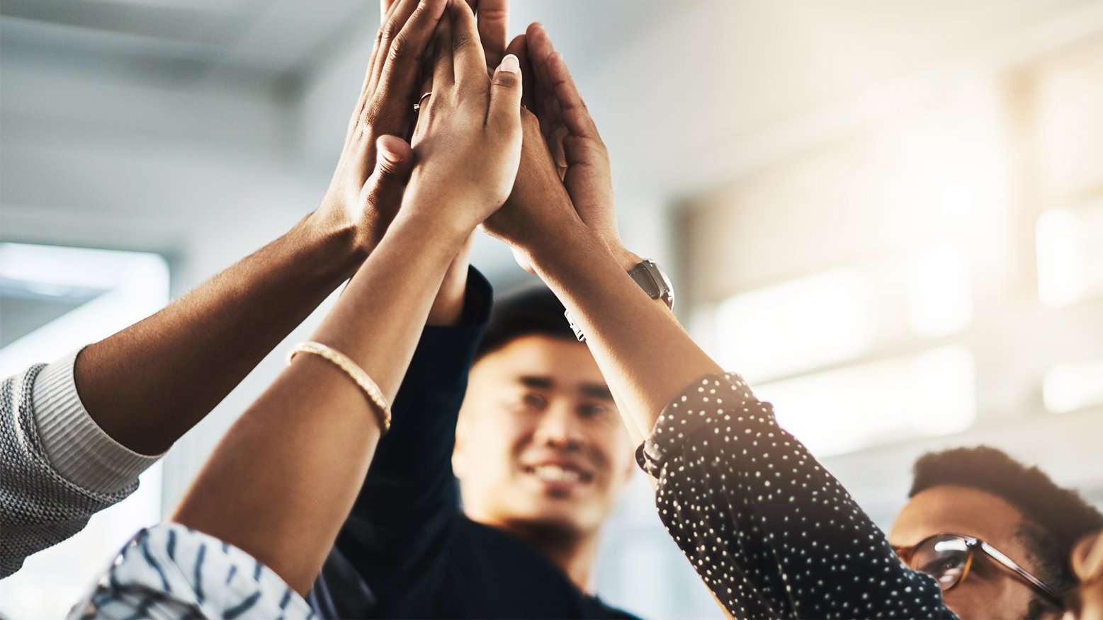 Hands of team members giving each other high fives.