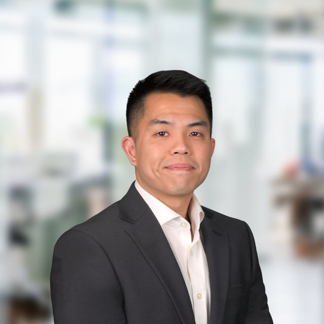 Portrait of a man in a blazer with a blurred background.