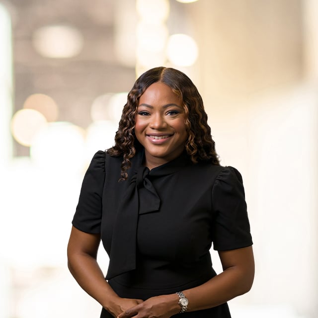 Professional portrait of a woman in a black dress, smiling.