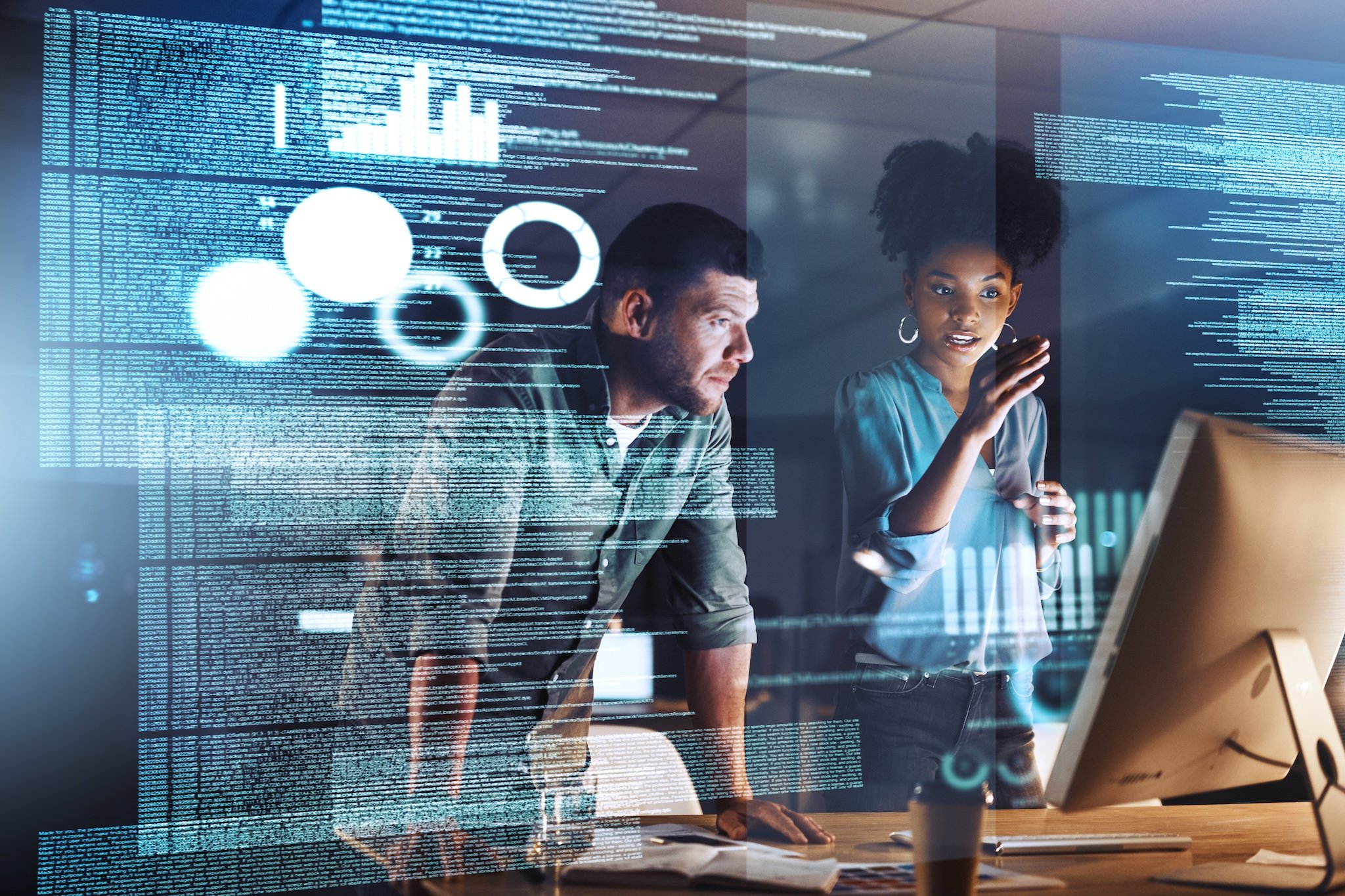 Man and woman looking at a computer screen with code.  Software development and coding concept.