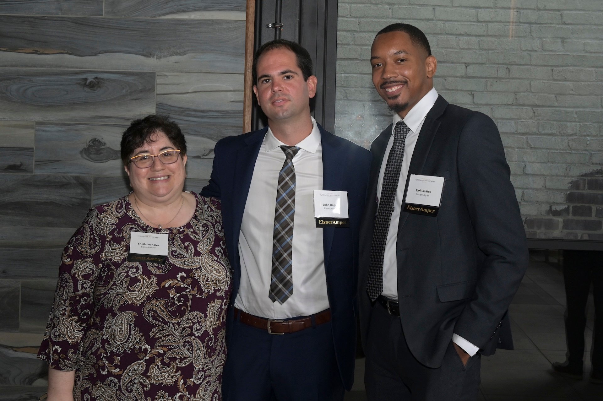 Group of three people at an event. All are wearing name tags.