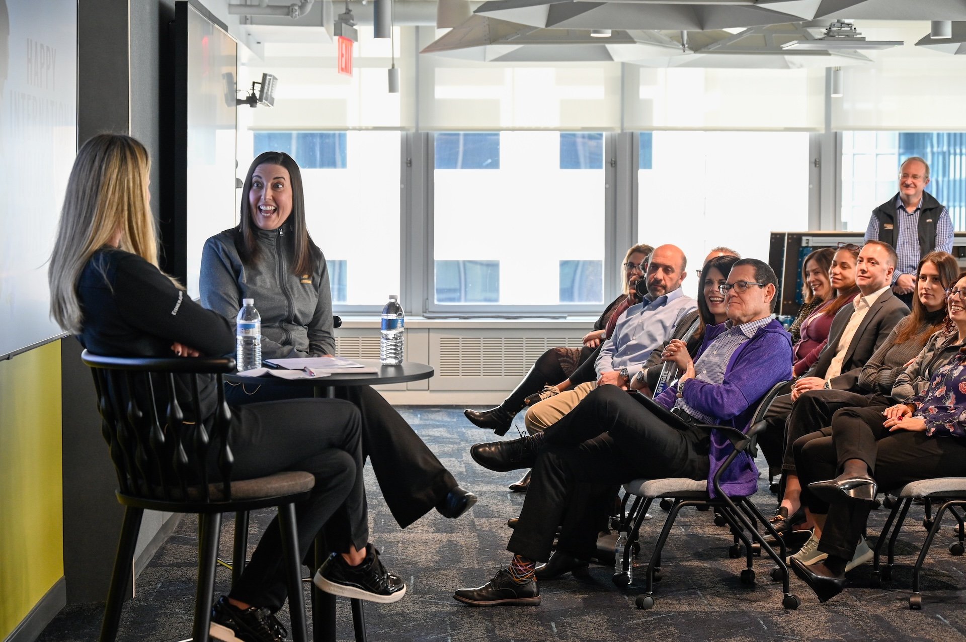 People in a conference setting listening to a presentation.