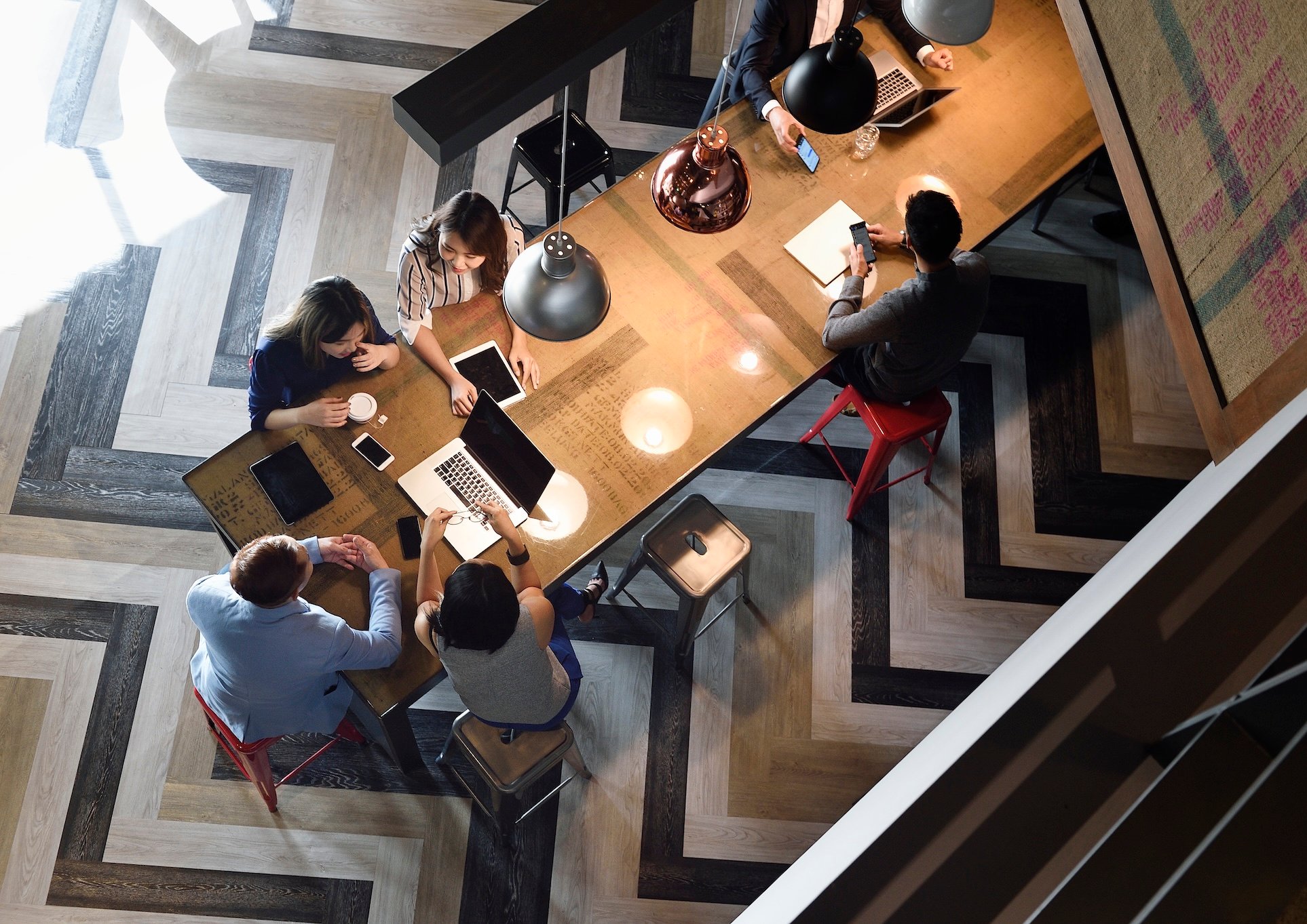 People gathered around a table with laptops and phones.