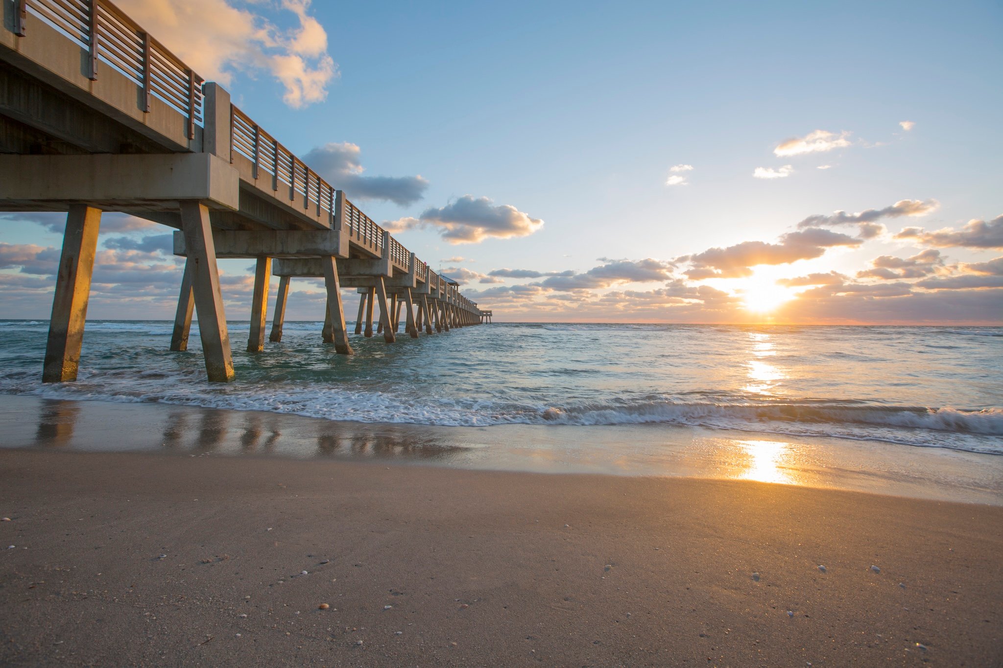 Beach, pier, ocean, and sunrise.
